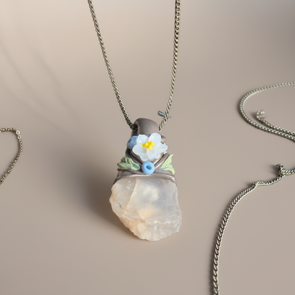 Kalnu kristāla amulets ar brūnu apdari un vienu ziediņu